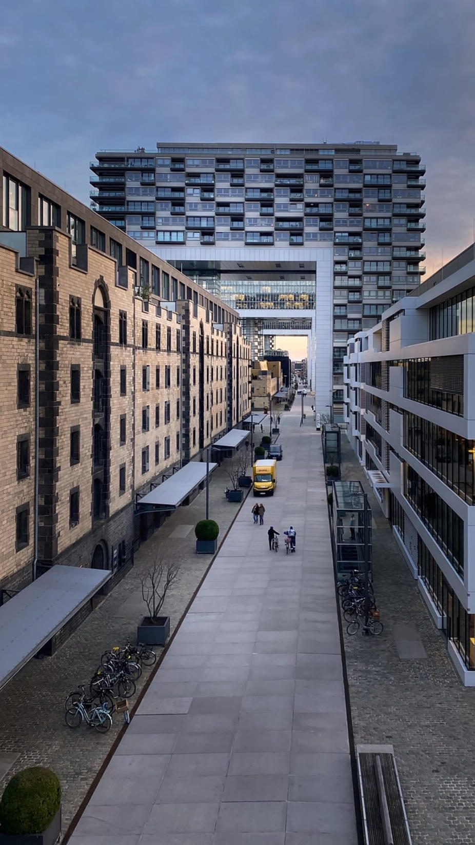 Moderne Architektur mit Gebäuden, einer Straße und Personen in einer urbanen Umgebung in Köln. 
